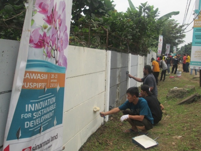 warga saat membersihkan Vandalisme di tembok yang berdiri di atas lahan Puspiptek Serpong.