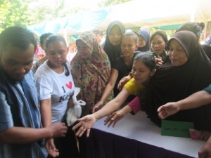  warga yang di dominasi ibu-ibu saat berebut sembako gratis yang di adakan komunitas wartawan Tangsel di halaman kecamatan Pondok Aren.