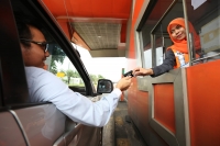 Pengguna jalan yang sedang bertransaksi menggunakan e-toll card