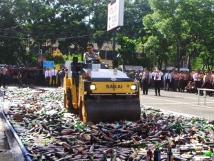 Kapolres saat memusnahkan miras dengan alat berat - Kapolres,Wakil walikota dan unsur terkait saat melempar botol miras untuk dimusnahkan