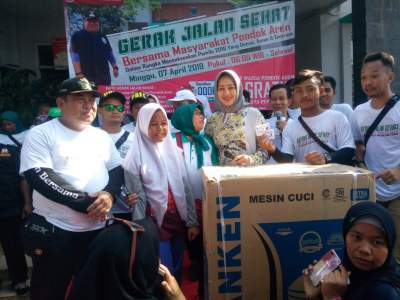 Walikota Airin saat menyaksikan pemberian doorprize kepada peserta gerak jalan sehat di Kelurahan Pondok Aren.