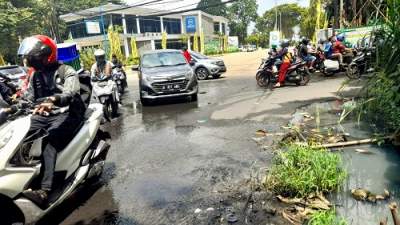 Tumpahan air di atas aspal jalan pertigaan Tanah Tingal, Ciputat.