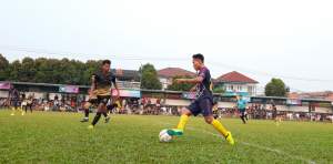 Pemain Denis FC, Hafid Ali drible bola untuk lewati hadangan pemain Tujuh FC, Fauzan.