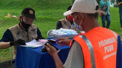 Seorang pelanggar PSBB kenakan rompi oranye dilakukan pendataan oleh Pol PP Tangsel.