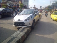 Depok-Mobil sedan yang nyangkut di trotoarf kota depok,minggu (23/2)